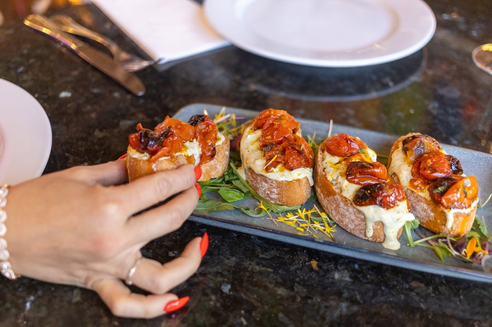 Bruschetta with roasted cherry tomatoes and creamy burrata on a slate
