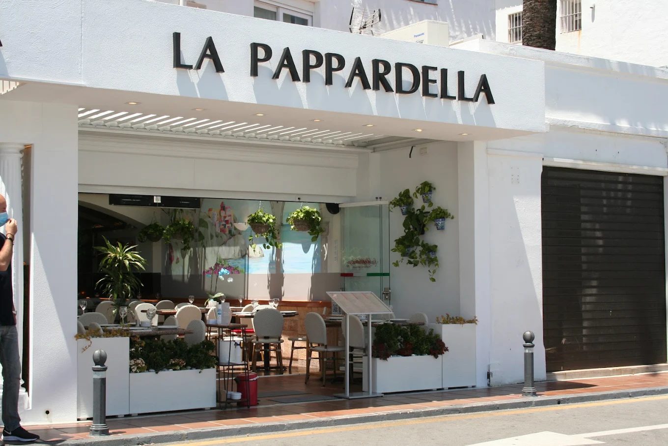 The white exterior of La Pappardella on the Puerto Banús promenade