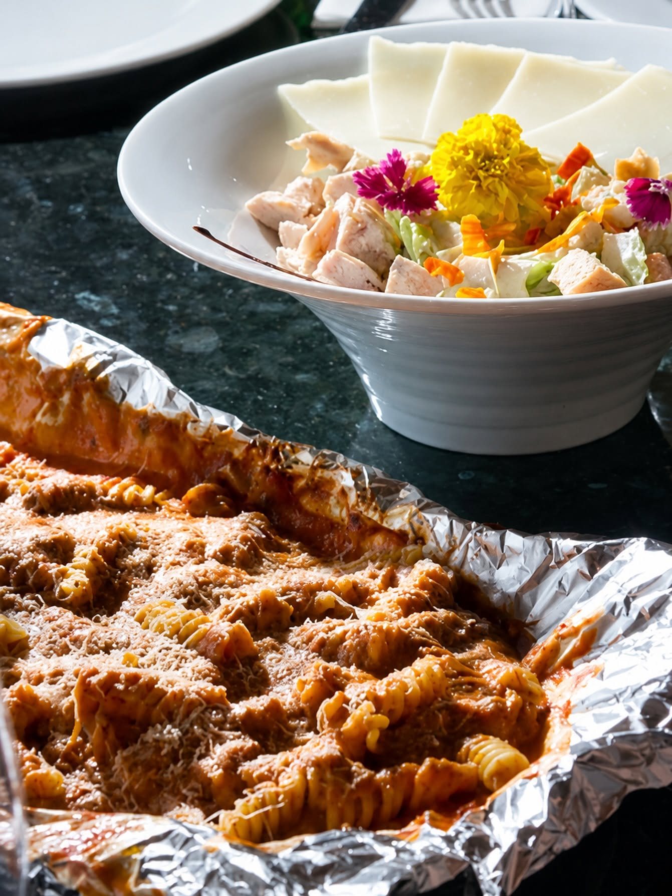 Pasta baked and served in foil under a snow of grated parmesan