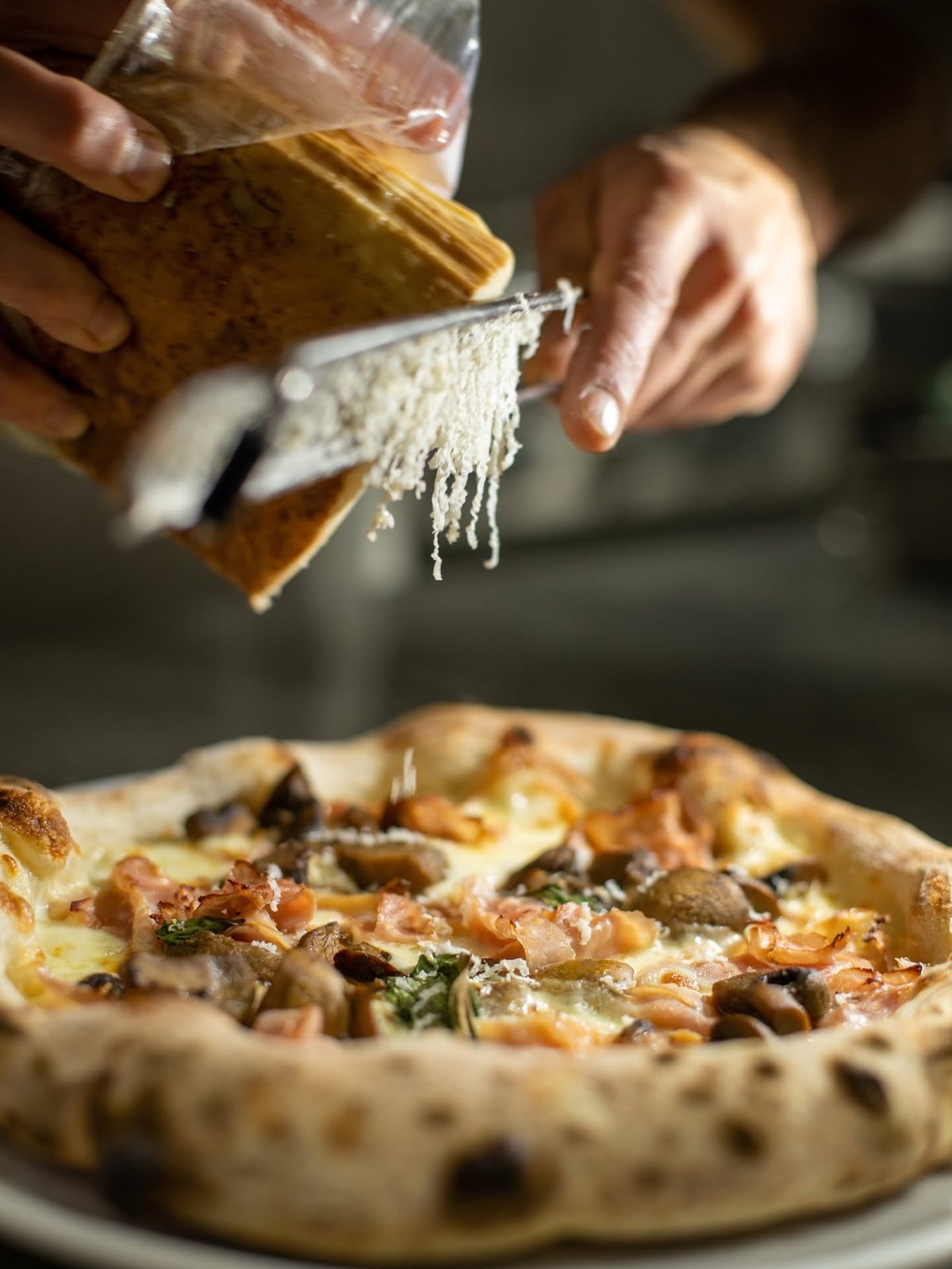 Parmesan grated over a finished white pizza